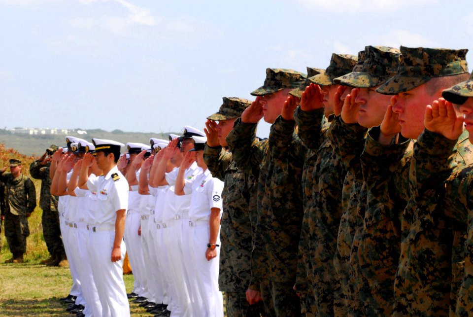 US Navy 070314-N-4124C-035 Marines render salutes alongside members of the Japan Maritime Self Defense Force (JMSDF) during the presentation of colors at the 62nd Commemoration of the Battle of Iwo Jima