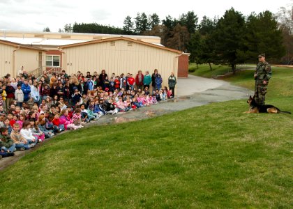 US Navy 070314-N-6247M-005 Master-at-Arms 2nd Class Phillip Kelman, with military working dog Nero, discusses the capabilities of the Military Police K-9 Program to students of Clover Valley Elementary School photo