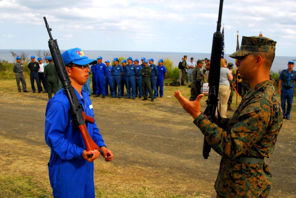 US Navy 070313-N-4124C-200 A Marine assigned to the 1st Marine Aircraft Wing (MAW) ceremonial guard demonstrates a rifle maneuver to a member of the Japan Maritime Self Defense Force