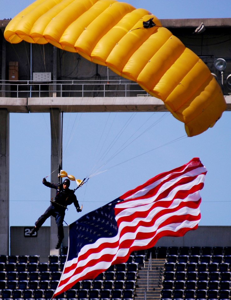 US Navy 070308-N-4163T-360 A member of the U.S. Navy Parachute Demonstration Team Leap Frogs descends into San Diego's Qualcomm Stadium with the American flag during a training session