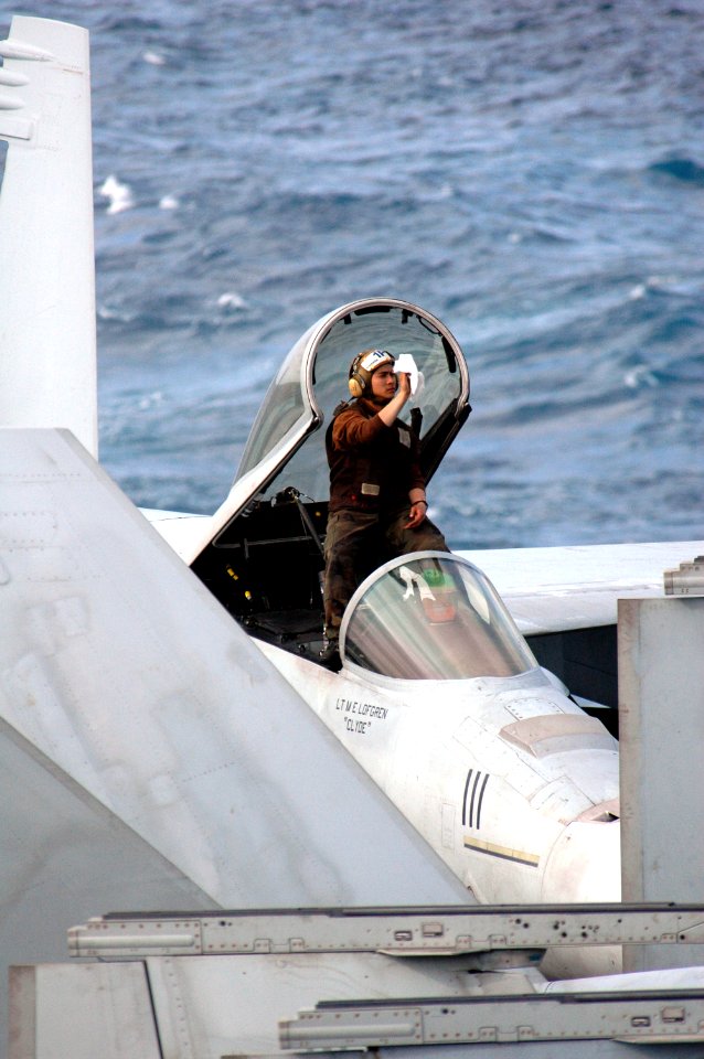 US Navy 070317-N-1635S-002 Standing in the cockpit of an F-A-18 on the flight deck of the Nimitz-class aircraft carrier USS Ronald Reagan (CVN 76), a Sailor cleans the inside windshield prior to flight operations