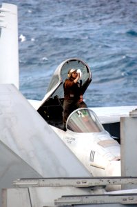 US Navy 070317-N-1635S-002 Standing in the cockpit of an F-A-18 on the flight deck of the Nimitz-class aircraft carrier USS Ronald Reagan (CVN 76), a Sailor cleans the inside windshield prior to flight operations photo