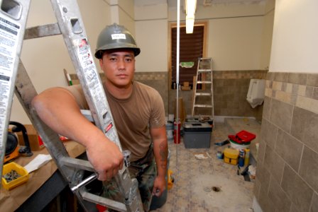 US Navy 070315-N-4965F-003 Utilitiesman 2nd Class Darwin Naigan, assigned to Naval Facilities Engineering Command, Hawaii (NAVFAC), takes a break during renovations to a male head at Naval Station Pearl Harbor