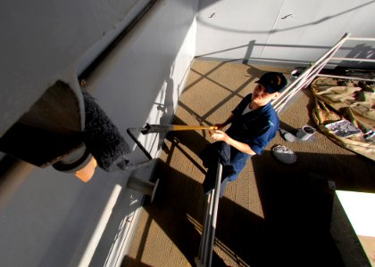 US Navy 070313-N-7981E-067 Seaman John Gulley, assigned to deck department, applies gray paint to bulkheads on a weather deck aboard Nimitz-class aircraft carrier USS Abraham Lincoln (CVN 72)