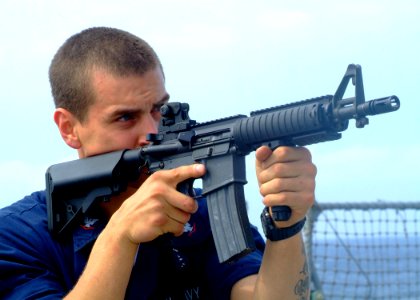 US Navy 070311-N-0120A-048 Engineman 3rd Class David Gomez-Hernandez, assigned to dock landing ship USS Harpers Ferry (LSD 49), practices watching his shipmates background during a non-compliant Visit, Board, Search and Seizure