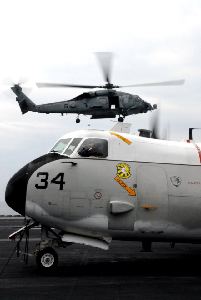 US Navy 070314-N-3659B-197 An SH-60F Seahawk, assigned to the Black Knights of Helicopter Anti-Submarine Squadron (HS) 4, prepares to touch down behind a C-2A Greyhound
