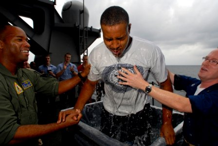 US Navy 070318-N-2659P-067 Lt. Anthony Carr, left, and Lt. Scott Callahan, right, baptize Aviation Ordnanceman Airman Robert Outlar during a religious ceremony on the fantail of Nimitz-class aircraft carrier USS John C. Stennis photo