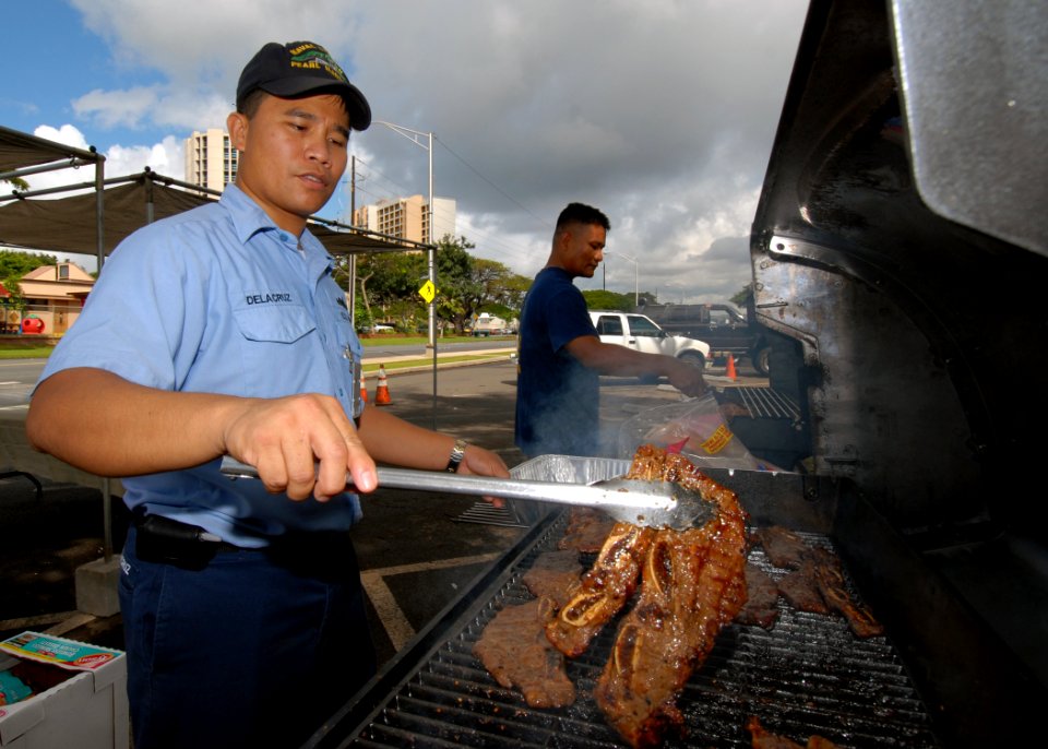 US Navy 070315-N-4965F-005 Culinary Specialist 1st Class Arnel Delacruz, assigned to Naval Station Pearl Harbor's Transient Personnel Unit, cooks ribs for a fund raising barbecue sponsored by the 1st Class Petty Officer^r