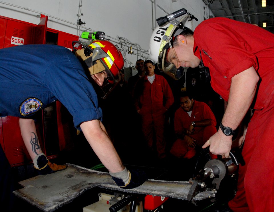 US Navy 070317-N-3038W-041 Damage Controlman 2nd Class Timothy Roney, left, and Damage Controlman 2nd Class Michael Coshatt, right, demonstrate how to use the portable hydraulic access rescue system