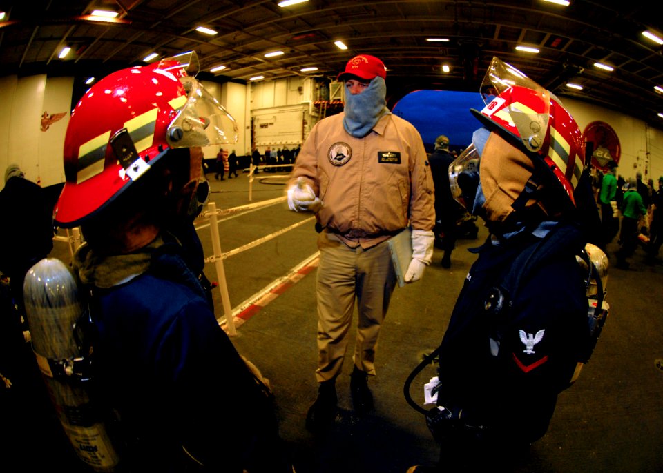 US Navy 070320-N-7981E-302 Chief Personnel Specialist James Robertson, a member of Lincoln's Damage Control Training Team, debriefs fire team members near the end of a general quarters drill