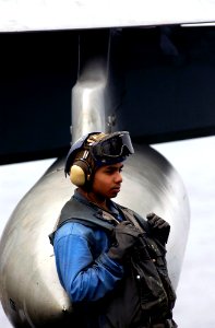 US Navy 070316-N-7130B-138 An F-A-18 Hornet is directed into parking position aboard USS Ronald Reagan (CVN 76) as Airman Michael Perez from Sylmar, Calif., rests on the fuel drop tank
