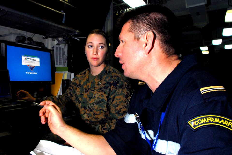 US Navy 070321-N-2659P-010 1st Lt. Arianne Boldizar,left, assigned to Marine Strike Fighter Squadron (VMFA) 323, discusses coalition operations with French Master Chief Pasacal Gonzalez from the French Navy Ship (FNS) Charles d