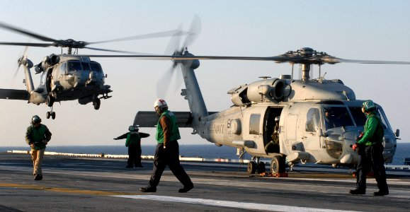 US Navy 070321-N-5345W-005 Sailors assigned to the Dusty Dogs of Helicopter Anti-Submarine Squadron (HS) 7 watch as one of their HH-60H Seahawks approaches the flight deck