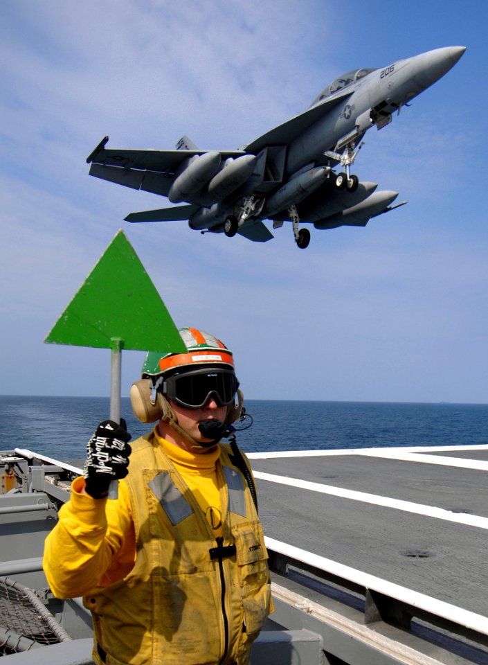 US Navy 070322-N-5345W-011 Flight deck supervisor, Lt. Walter Massenburg displays the 'green deck' paddle as an F-A-18F Super Hornet, assigned to the