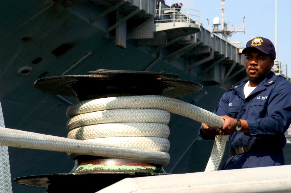 US Navy 070322-N-9520G-002 Boatswain's Mate 3rd Class Rueben Lee uses a capstan to remove slack on a double-braided line used on tugboats moored at Commander Fleet Activities Yokosuka