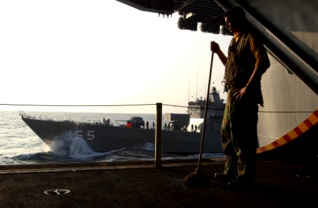 US Navy 070317-N-4009P-033 In the early morning hours, Aviation Boatswain's Mate Handling 3rd Class from Bolivar, Mo., takes a moment away from his cleaning duties to observe Japan Maritime Self Defense Force (JMSDF) shi