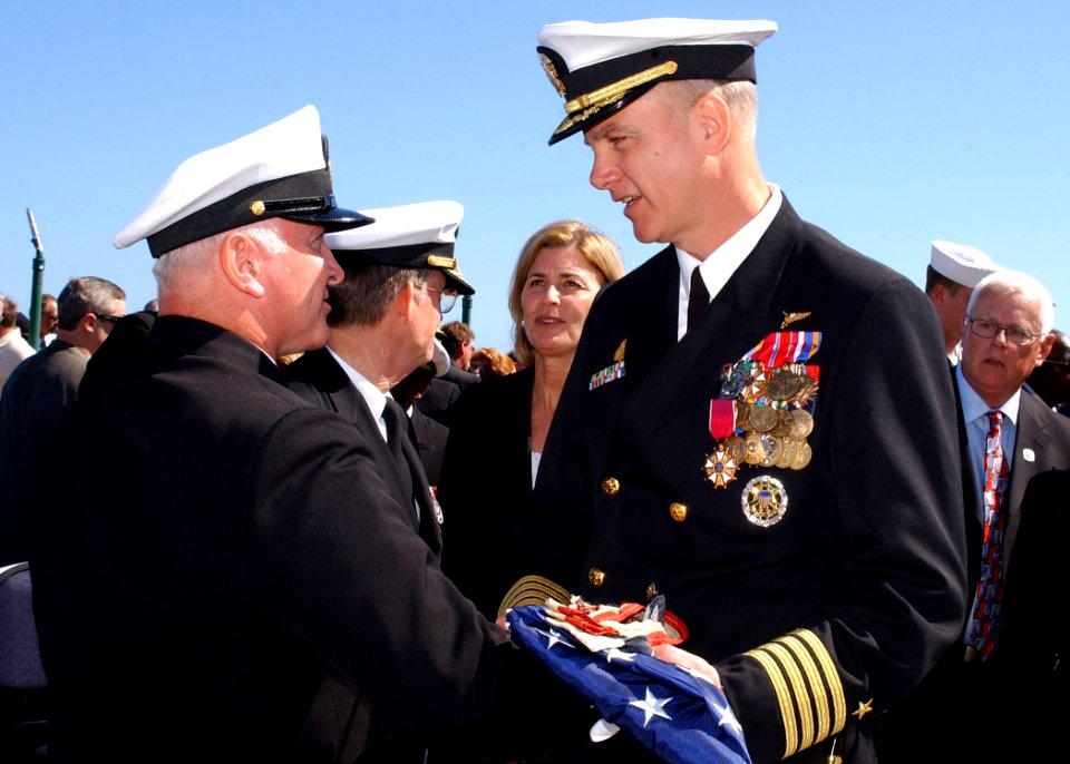 US Navy 070323-N-8544C-160 Command Master Chief Charles L. Dassance presents the ensign to USS John F. Kennedy (CV 67) Commanding Officer Capt. Todd A. Zecchin during the historical decommissioning ceremony of the aircraft carr