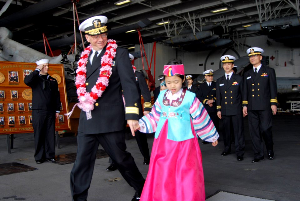 US Navy 070322-N-3659B-062 Commander, Carrier Strike Group (CCSG) 7, Rear Adm. Charles Martoglio escorts a local area child on a visit aboard the Nimitz-class aircraft carrier USS Ronald Reagan (CVN 76) after mooring the ship i