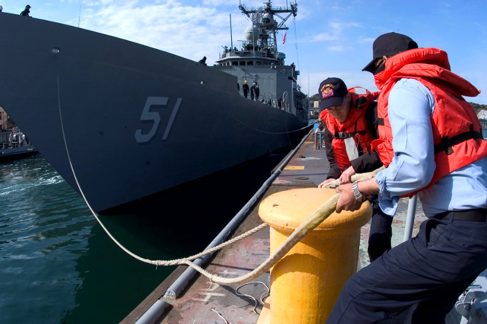 US Navy 070320-N-5253W-001 Pierside line handlers release a forward mooring line from the bollards as the Oliver Hazard Perry-class guided missile frigate USS Gary (FFG 51) gets underway on board Commander Fleet Activities Yoko
