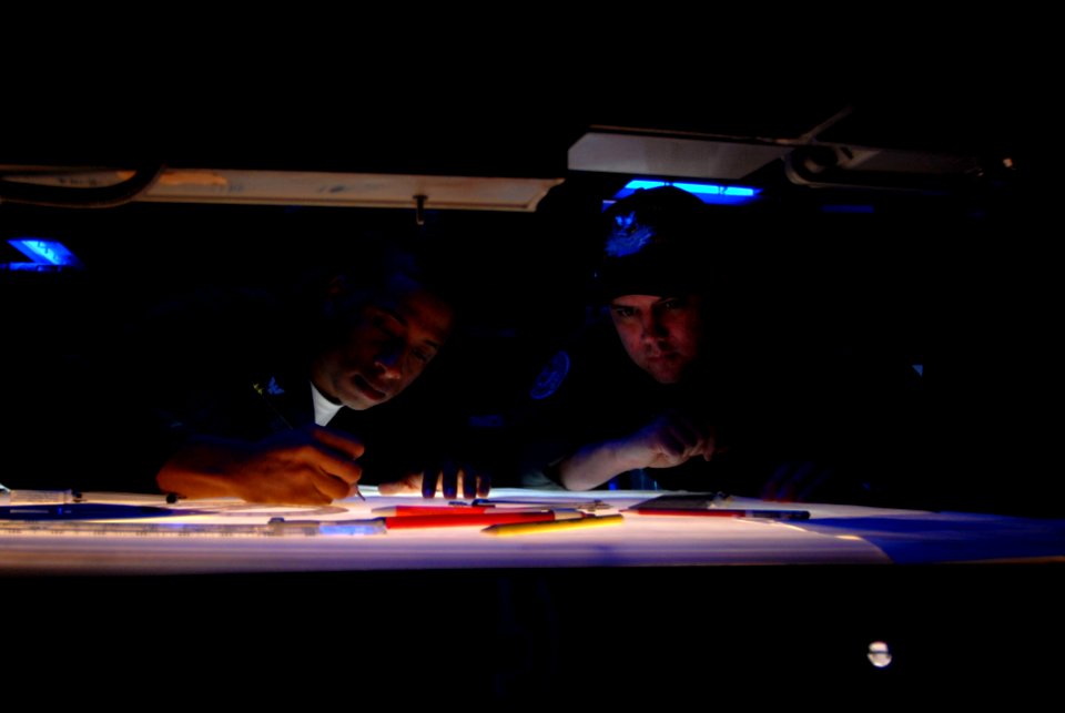 US Navy 070322-N-2659P-023 Aviation Systems Warfare Operator 2nd Class Patrick Charlot, left, and Aviation Systems Warfare Operator 2nd Class Matt McMillan work together on the Tactical Plotting Table to plot where the John C