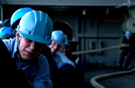 US Navy 070322-N-7130B-311 Deck seamen, assigned to deck department aboard Nimitz-class aircraft carrier USS Ronald Reagan (CVN 76), heave around the a mooring line on the ship's fantail