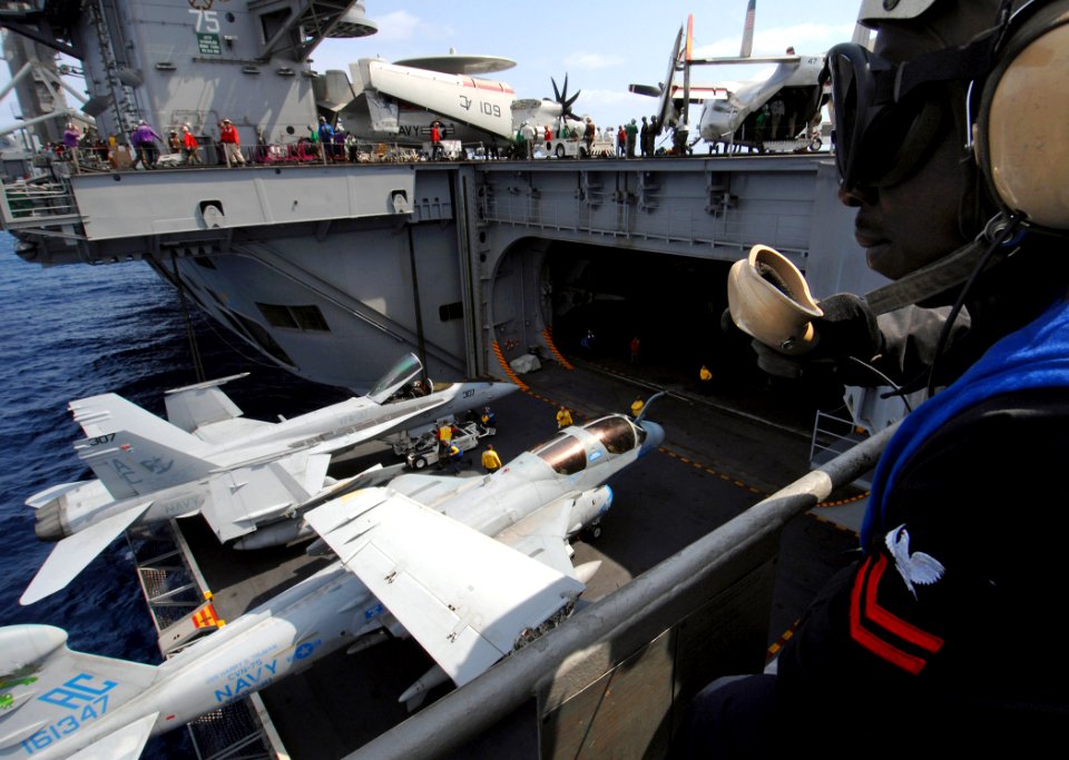 US Navy 070327-N-5345W-058 Aviation Boatswain's Mate 2nd Class Dalix Mondestin prepares to relay a message to flight deck control as an F-A-18C Hornet assigned to Strike Fighter Squadron (VFA) 37