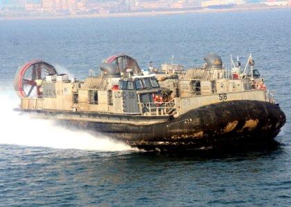 US Navy 070323-N-6710M-001 A landing craft air cushion (LCAC) prepares to enter the well deck of dock landing ship USS Tortuga (LSD 46) while passing by amphibious transport dock USS Juneau (LPD 10)