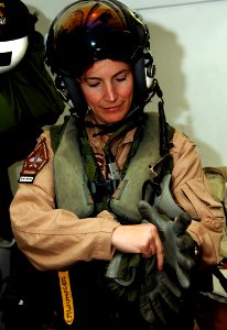 US Navy 070324-N-8923M-079 Commanding Officer Cmdr. Sara Joyner of Strike Fighter Squadron (VFA) 105, puts on her gloves while dressing out in full flight gear before flight operations aboard Nimitz-class aircraft carrier USS H
