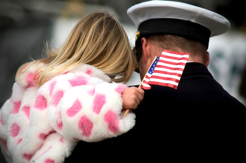 US Navy 070321-N-5253W-004 A young girl clings to her father, an officer aboard the amphibious command ship USS Blue Ridge (LCC 19), following the ship's return from a scheduled underway period