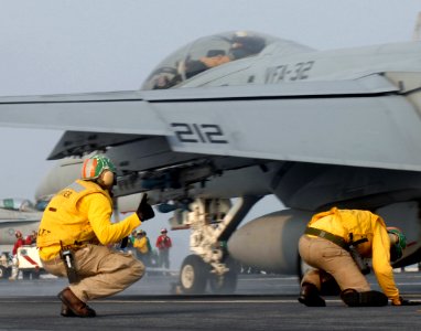 US Navy 070328-N-5345W-153 Flight deck shooters brace themselves against impending jet blast as an F-A-18F Super Hornet