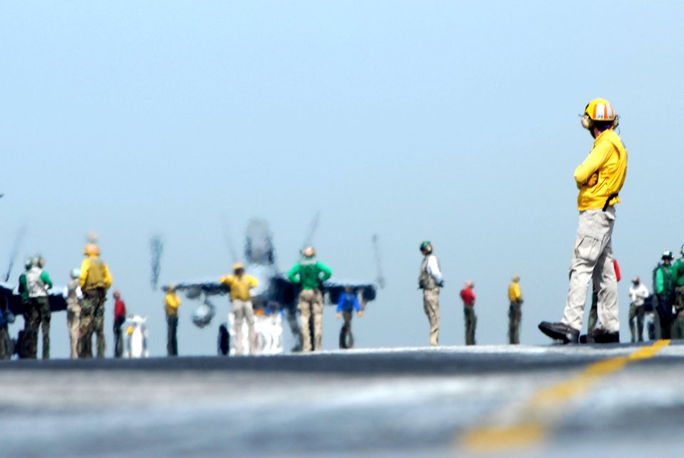 US Navy 070327-N-2659P-210 A flight deck director from air department's launch and recovery division waits for the next taxiing aircraft to line up for take-off