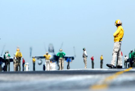 US Navy 070327-N-2659P-210 A flight deck director from air department's launch and recovery division waits for the next taxiing aircraft to line up for take-off