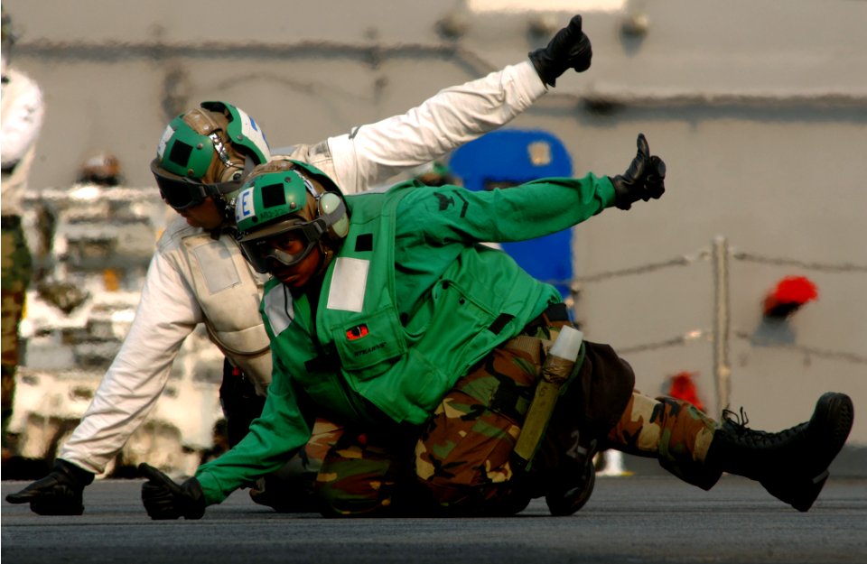 US Navy 070328-N-5345W-134 Final checkers, assigned to the Swordsmen of Strike Fighter Squadron (VFA) 32, give the clear to launch signal