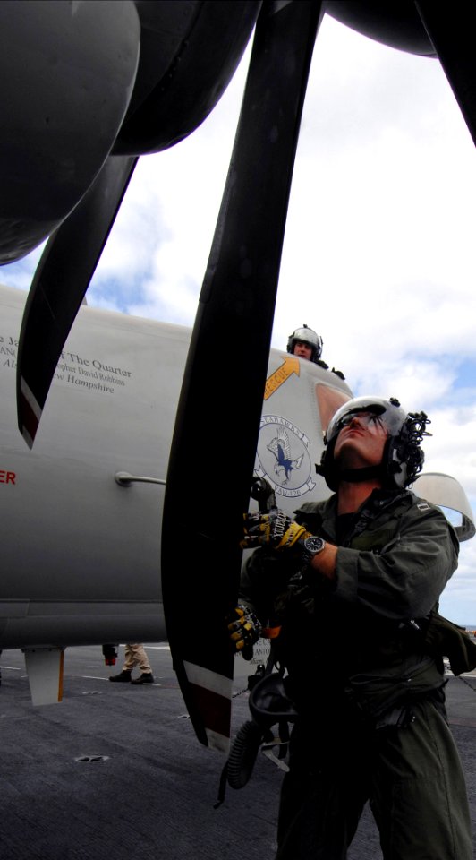 US Navy 070326-N-5345W-086 Lt. Troy Nesbitt, a naval flight officer assigned to the Seahawks of Carrier Airborne Early Warning Squadron (VAW) 126, inspects the propeller of an E-2C Hawkeye