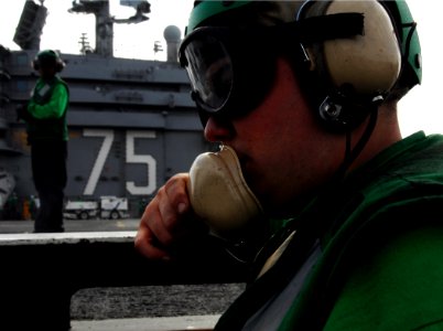 US Navy 070326-N-8923M-042 Airman Todd Simmons conducts sound checks while manning the waist catapult jet blast deflector (JBD) controls aboard Nimitz-class aircraft carrier USS Harry S. Truman (CVN 75)