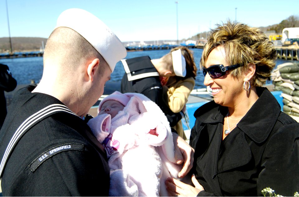 US Navy 070329-N-8467N-004 Electronics Technician 3rd Class Jeremy Boord admires his new daughter for the first time as his wife looks on
