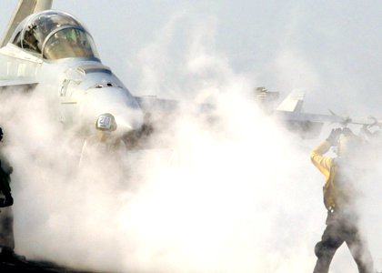 US Navy 070327-N-8446A-002 A plane director moves an F-A-18F Super Hornet, assigned to the Jolly Rogers of Strike Fighter Squadron (VFA) 103, into launch position aboard Nimitz-class aircraft carrier USS Dwight D. Eisenhower (C