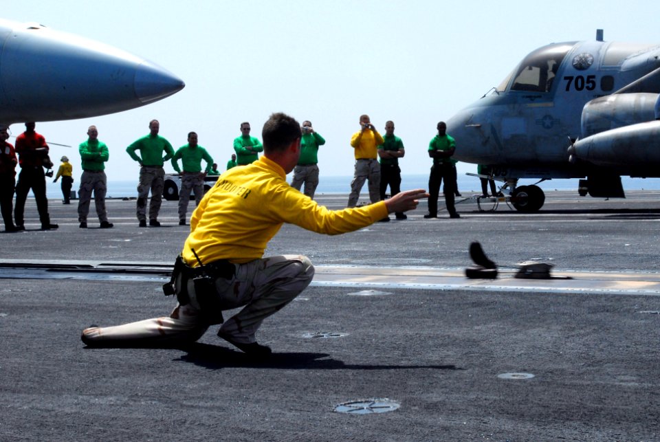 US Navy 070326-N-2659P-061 Lt. Cmdr. Matthew Villarreal gives the final signal to launch a pair of his boots off the flight deck aboard Nimitz-class aircraft carrier USS John C. Stennis (CVN 74)