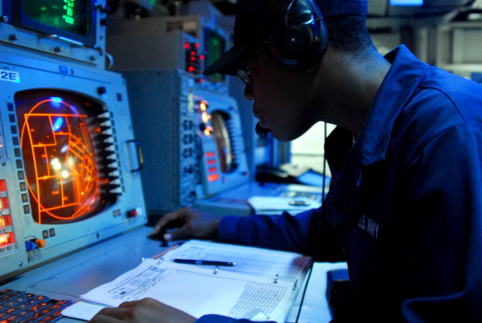 US Navy 070329-N-4124C-011 Operations Specialist Seaman Recruit Louisdes J. Ambroise, attached to Amphibious Squadron (PHIBRON) 11, monitors tracks on a radar screen in the PHIBRON flag plot aboard the amphibious assault ship U