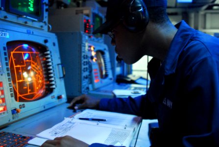 US Navy 070329-N-4124C-011 Operations Specialist Seaman Recruit Louisdes J. Ambroise, attached to Amphibious Squadron (PHIBRON) 11, monitors tracks on a radar screen in the PHIBRON flag plot aboard the amphibious assault ship U