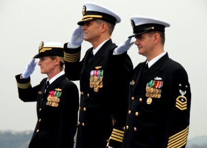 US Navy 070327-N-9860Y-027 Commander, Expeditionary Strike Group 7-Task Force 76, Rear Adm. Carol Pottenger, Capt. David A. Lausman, and Command Master Chief John Becker render honors to the color guard during the opening of th photo