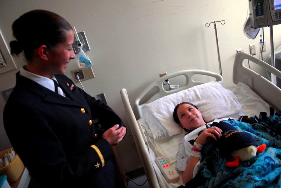 US Navy 070329-N-4776G-189 Ensign Michelle Back, from Albuquerque, N.M., presents an inpatient at Riverside County Regional Medical Center, Children's Hospital with a command ball cap from guided missile frigate USS Thatch (FFG