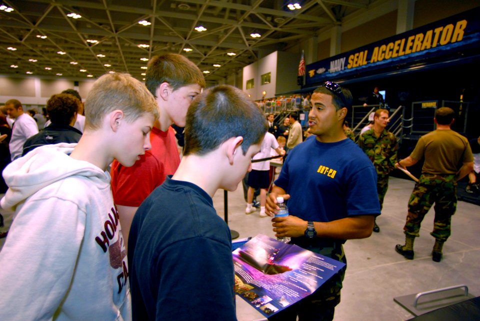 US Navy 070330-N-4515N-009 Special Warfare Boat Operator 2nd Class Ronnie Longoria from Special Boat Team 20 talks with high school students attending the National High School Wrestling Championship at the Virginia Beach Conven