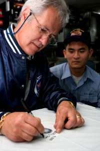 US Navy 070329-N-8591H-134 Alex Trebek of the trivia game show Jeopardy^ along with USO members and the Jeopardy film crew receive a brief about USS Kitty Hawk's (CV 63) capabilities