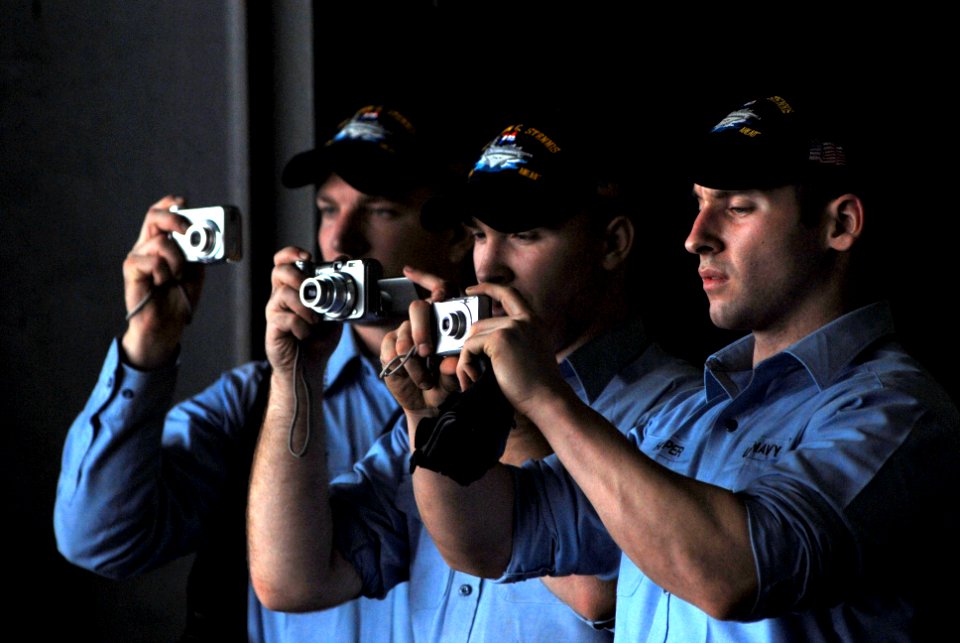 US Navy 070329-N-2659P-023 Sailors gather in the hangar bay of the Nimitz-class aircraft carrier USS John C. Stennis (CVN 74) to take pictures while passing land