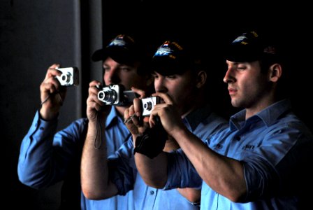 US Navy 070329-N-2659P-023 Sailors gather in the hangar bay of the Nimitz-class aircraft carrier USS John C. Stennis (CVN 74) to take pictures while passing land