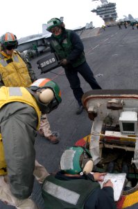 US Navy 070404-N-5484G-036 An Aviation Boatswain's Mate assigned to Air department relays the weight of an F-A-18C Hornet