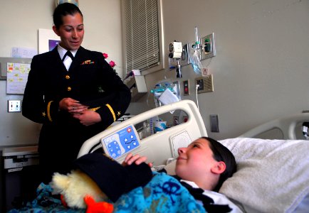 US Navy 070329-N-4776G-201 Ensign Michelle Back, from Albuquerque, N.M., presents an inpatient at Riverside County Regional Medical Center, Children's Hospital with a command ball cap from guided missile frigate USS Thatch (FFG
