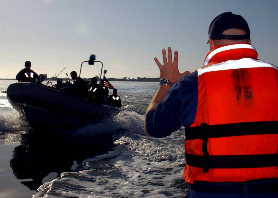 US Navy 070329-N-1810F-011 Boatswain's Mate 1st Class Matthew Masingill from Naval Station Mayport Harbor Operations signals to a boat team from guided missle frigate USS Kalkring (FFG 42)