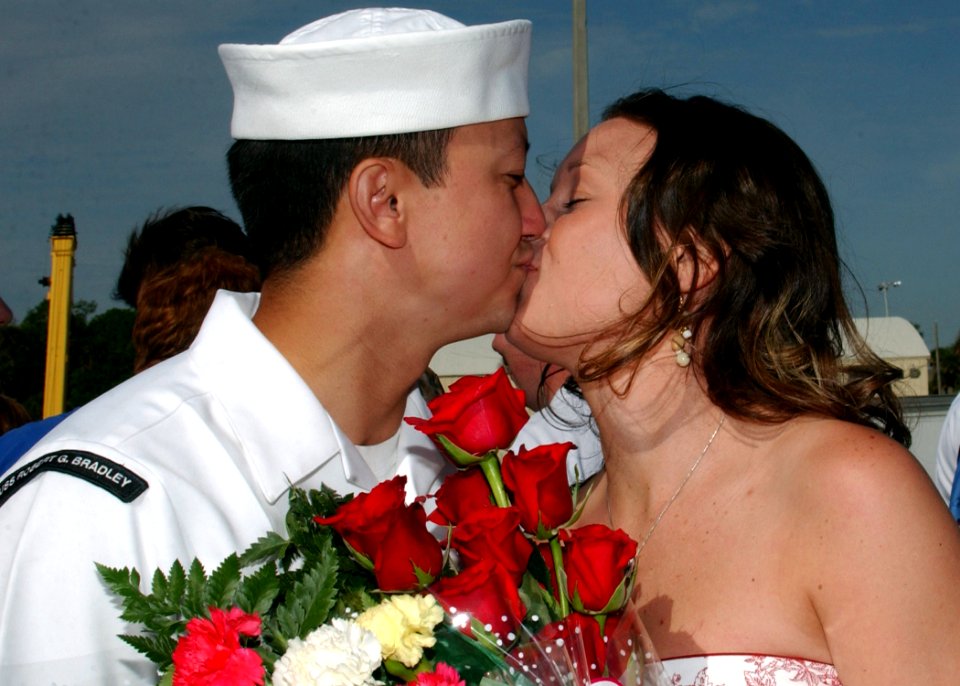 US Navy 070405-N-1810F-145 Gas Turbine System Technician (Mechanical) 1st Class Lee Mears attached to the guided-missile frigate USS Robert G. Bradley (FFG 49) enjoys the first kiss with his wife after returning from a six-mont